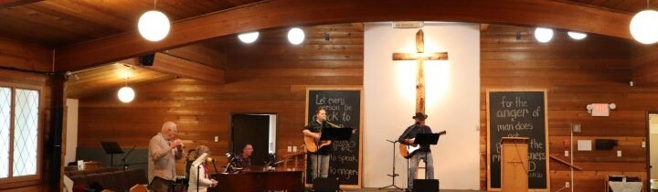 A team of musicians singing and playing instruments at the front of the sanctuary.